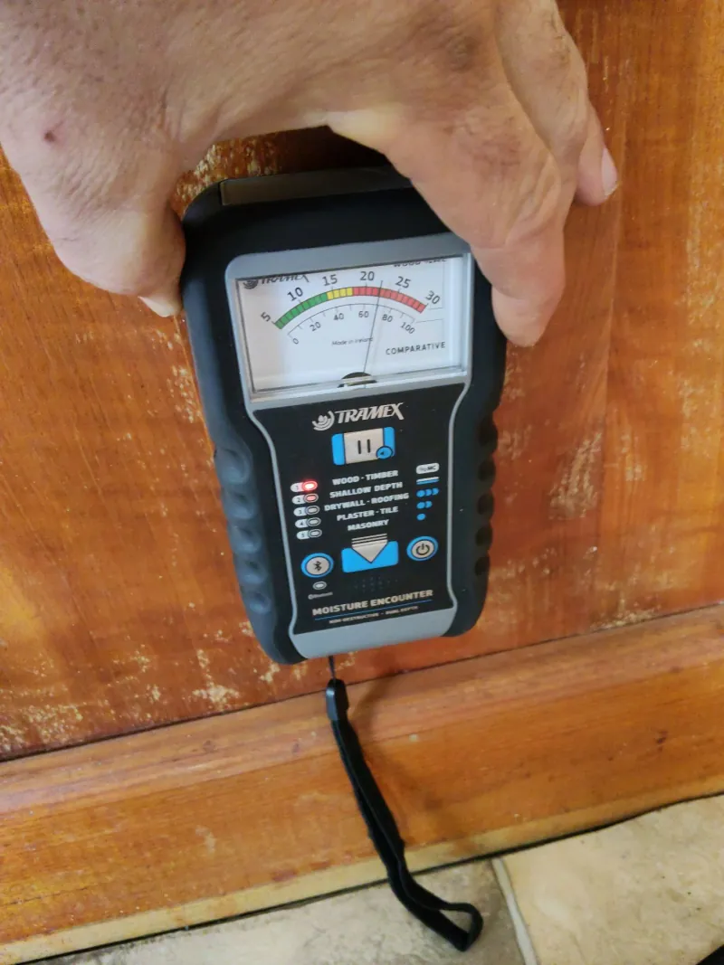 Moisture meter checking timber near the shower recess